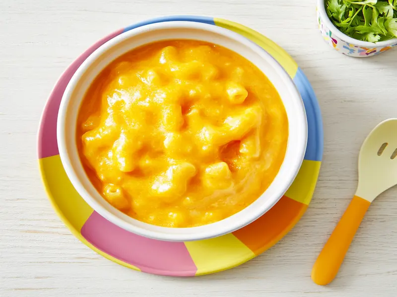 A bowl of creamy mac and cheese with hidden veggies served on a toddler plate — a comforting and nutritious example of toddler friendly meals.
