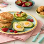 A collection of vibrant and healthy paleo meals for kids, including paleo pancakes, chicken tenders, and avocado egg cups, all served on colorful plates.